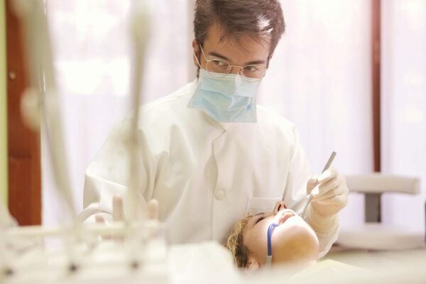 Man in White Button Up Shirt Holding Dental Tool